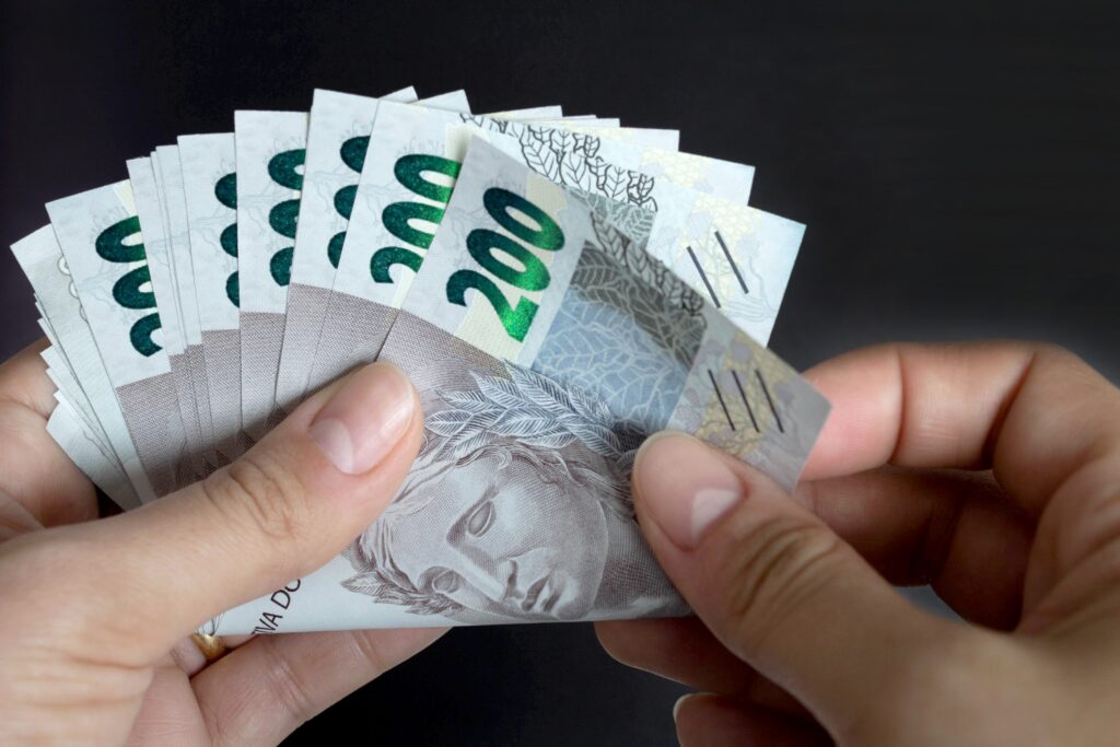 200 reais contando notas de dinheiro brasileiras scaled.jpg