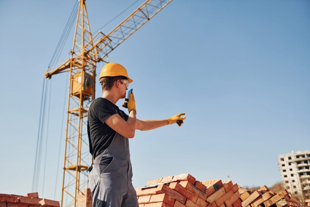 falando por telefone trabalhador da construcao civil em uniforme e equipamento de seguranca tem empr.jpeg