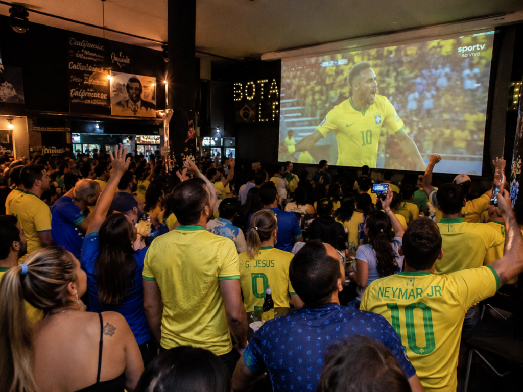 torcedores em bar vendo selecao brasileira no telao imagem gerada por ia.png