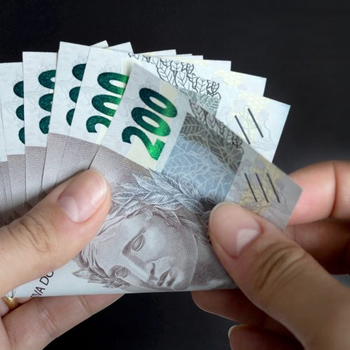 200 reais contando notas de dinheiro brasileiras scaled.jpg